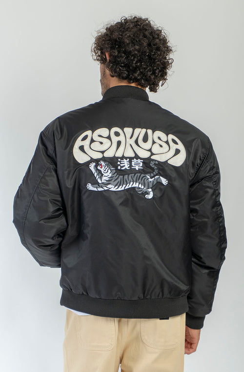 Chaqueta bomber negra Asakusa con parches bordados y gráfico de tigre de inspiración japonesa en la espalda.