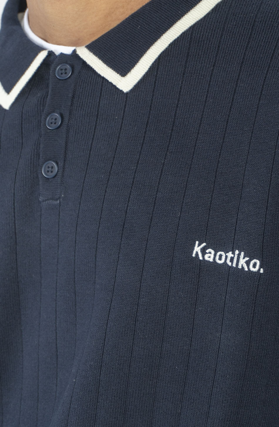 Polo unisex de punto azul marino de canalé con cuello de botones, detalles en contraste color crudo y bordado Kaotiko en el pecho.