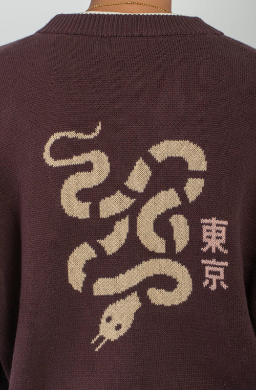 Cardigan unisex de punto marrón con botones, bordado Kaotiko Society en el pecho y gran jacquard de serpiente con detalles inspirados en Japón en la espalda.