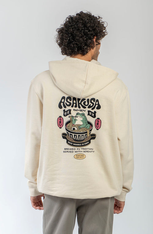 Sudadera oversize unisex de algodón orgánico color crudo con gráfico Asakusa Ramen en el pecho e ilustración de una rana en un bol de ramen en la espalda.