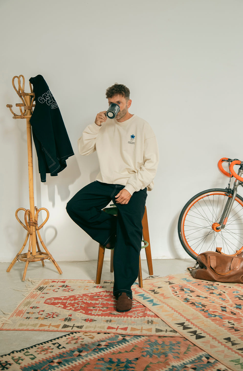 Sudadera unisex oversize color ivory con gráfico Kaotiko Society en el pecho y estampado Just Breezing en la espalda.